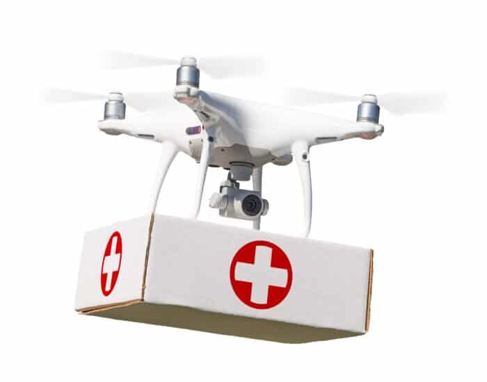 Unmanned Aircraft System (UAS) Quadcopter Drone Carrying First Aid Package On White.